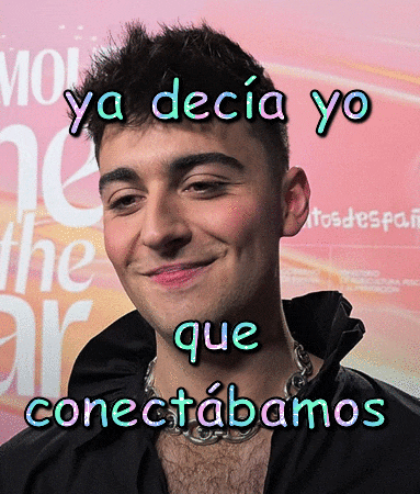 a man with a necklace around his neck is smiling in front of a sign that says " ya decia yo "