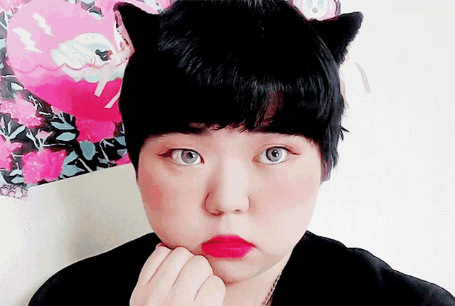 a woman wearing a cat ear hat with red lips