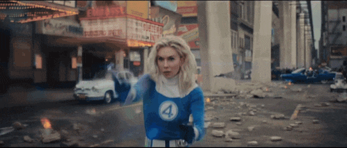 a woman in a fantastic four costume stands in a city street