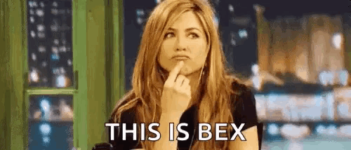 a woman is sitting at a table with her finger on her chin and a caption that says `` this is bex '' .