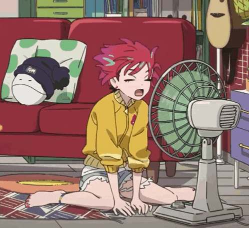 a girl with red hair is sitting in front of a fan and yawning