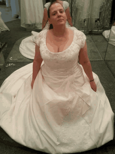 a woman in a white dress sits on the floor