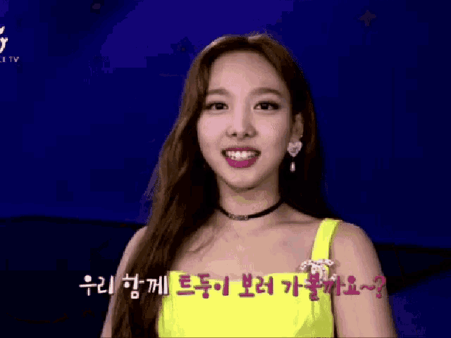 a woman in a yellow dress is making a funny face in a foreign language