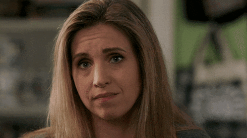 a woman with her eyes closed making a face
