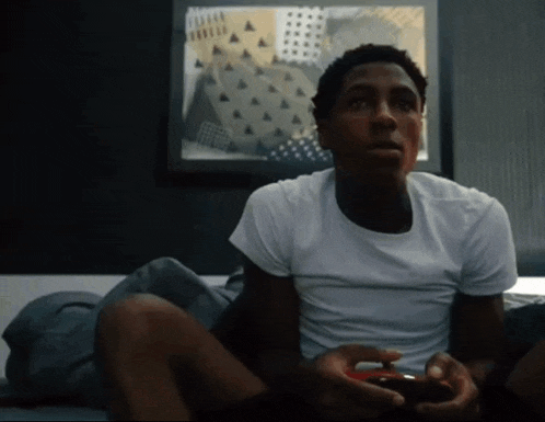 a man in a white shirt is holding a video game controller