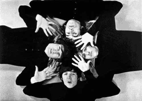 a black and white photo of the beatles with their hands around each other