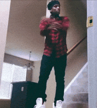 a man in a plaid shirt is standing on the stairs