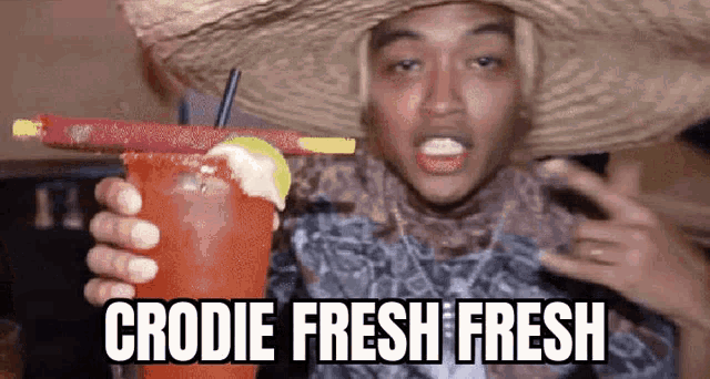 a man wearing a sombrero is holding a drink with a straw .