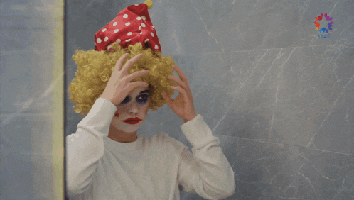 a person in a clown costume is looking at their face in a mirror