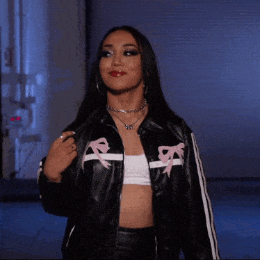 a woman in a black jacket with pink bows on it