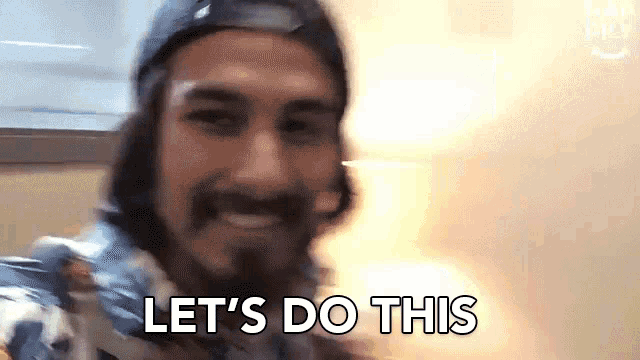a man with a beard is smiling and saying let 's do this .