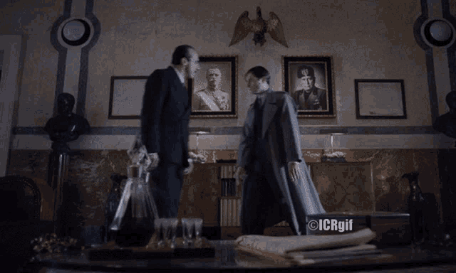 two men are walking in a room with icrgif written on the bottom right
