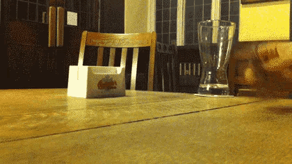 a napkin holder on a table next to a glass