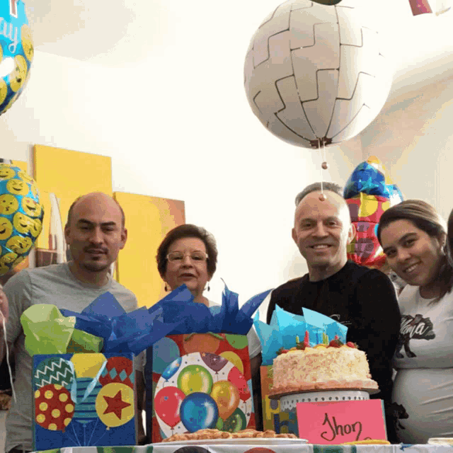 a group of people standing around a cake with a pink sign that says shop on it