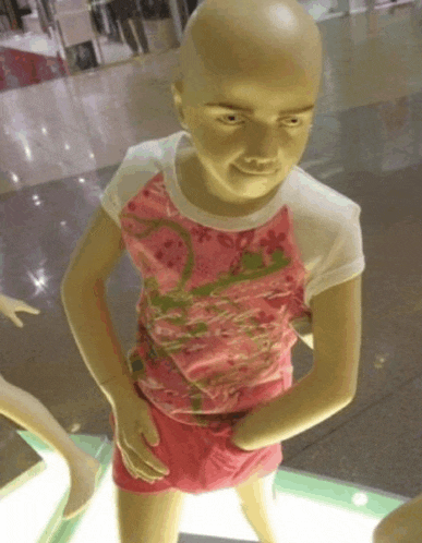 a mannequin with a bald head wearing a pink shirt and pink shorts