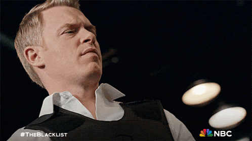 a man wearing a black vest with the blacklist written on the bottom