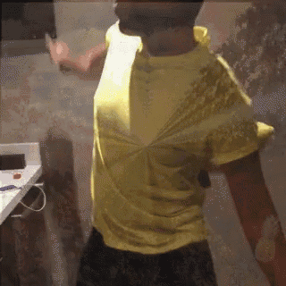 a man in a yellow shirt is standing in a room