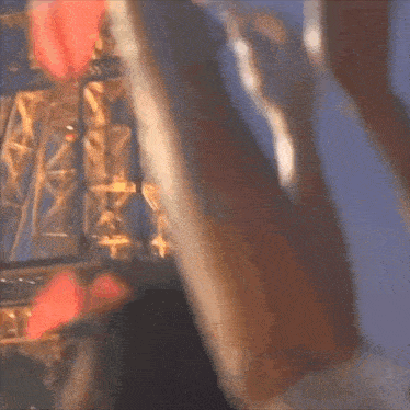 a blurry picture of a person standing in front of a ferris wheel .