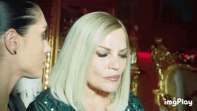 two women are looking at each other and the word imgplay is in the corner