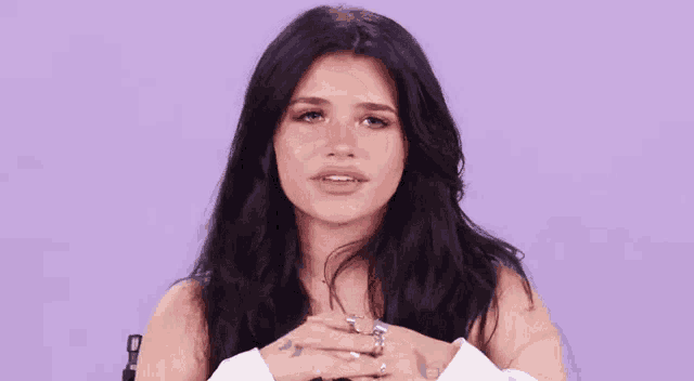 a woman with black hair is blowing a kiss with her hands