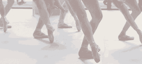 a group of young female ballet dancers are dancing in a studio .