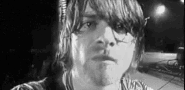 a close up of a man 's face in a black and white photo on a stage .