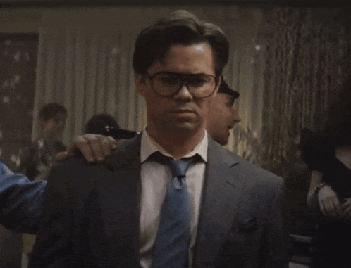 a man in a suit and tie with glasses on