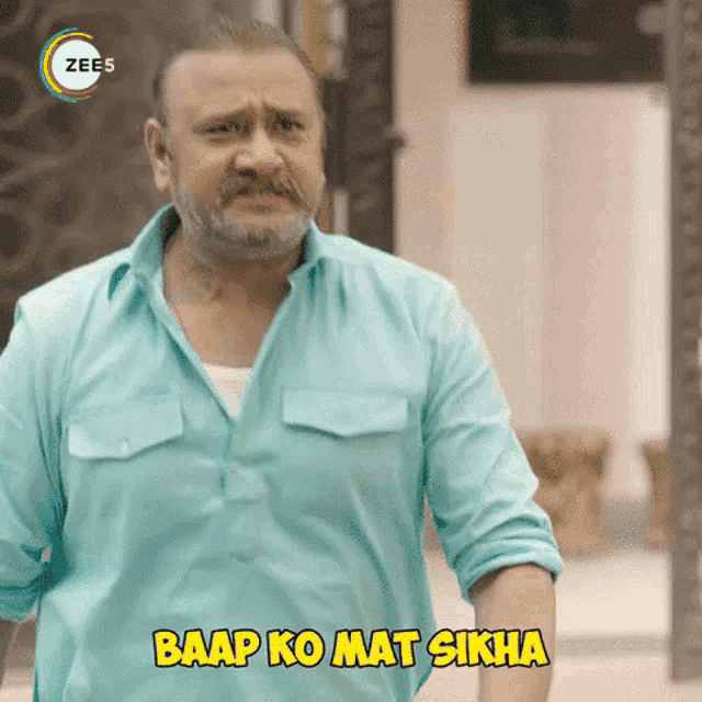 a man with a beard and mustache is wearing a blue shirt and saying baap ko mat sikha