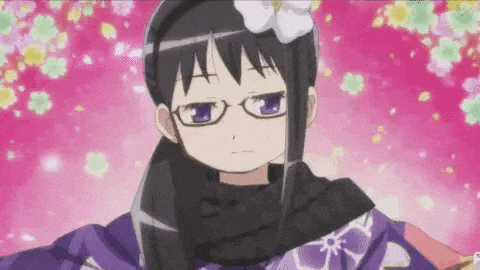 a girl wearing glasses and a scarf is standing in front of flowers .