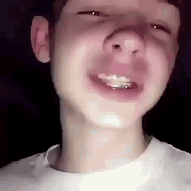 a close up of a young man 's face with braces on his teeth