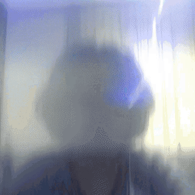 a blurred image of a person behind a glass