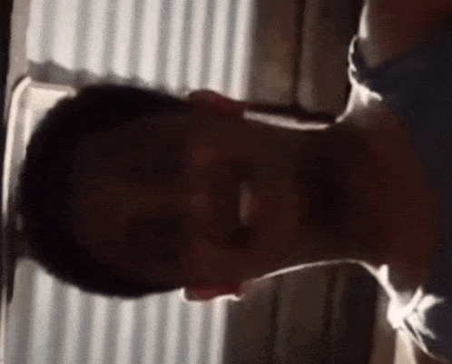 a close up of a man 's face with a shadow on the wall behind him