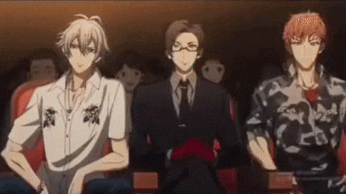 three anime characters are sitting in a theater .