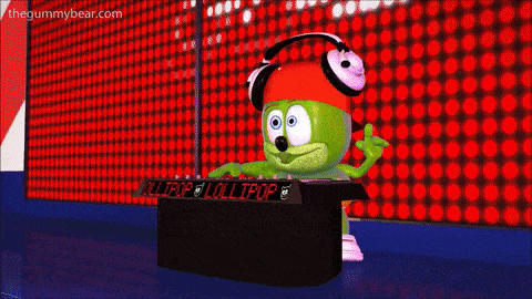 a green gummy bear wearing headphones and a red hat is playing a dj set