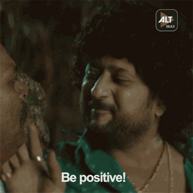 a man with a beard and a necklace says be positive