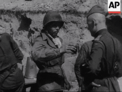 a black and white photo of a group of soldiers talking .