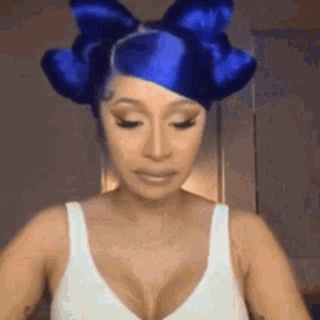 cardi b is wearing a blue wig with a bow in her hair .