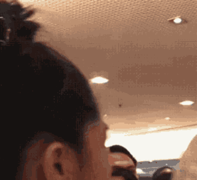 a close up of a person 's ear with a bun in their hair .