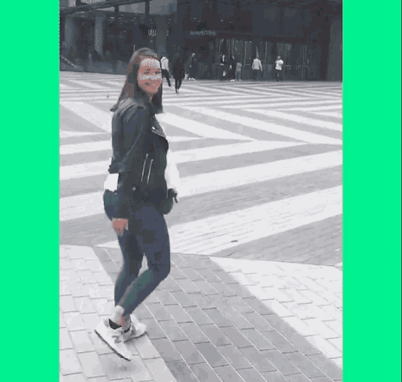 a woman in a leather jacket is walking down a brick sidewalk