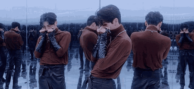 a man is standing in front of a mirror and looking at himself