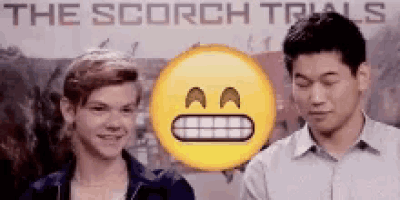 two young men are standing next to each other in front of a poster for the scorch trials .