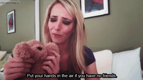 a woman is holding a teddy bear with the words put your hands in the air if you have no friends