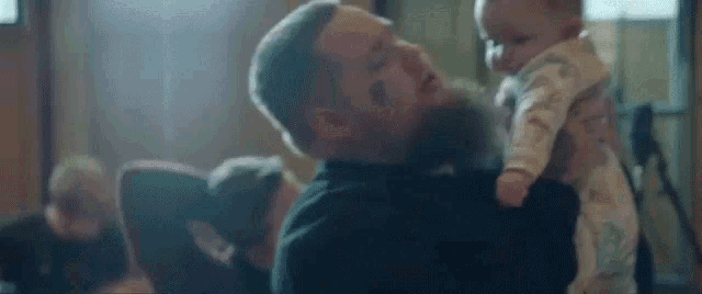 a man is kissing a baby on the cheek .
