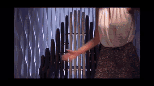 a woman in a white top and leopard print shorts is standing in front of a metal fence .