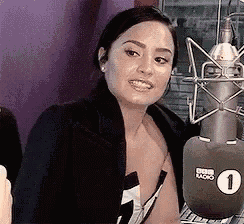 a woman is sitting in front of a microphone .