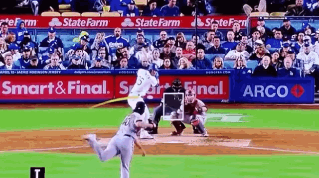 a baseball game is being played with ads for state farm and arco in the outfield