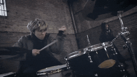 a man is playing drums in front of a drum set that says ' pearl ' on it