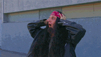 a man with long hair wearing a red bandana and a black jacket
