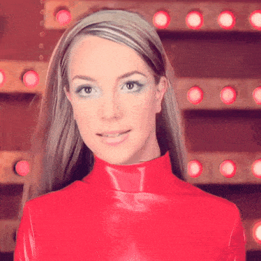 a woman wearing a red turtleneck is smiling