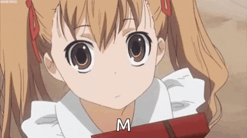 a little girl with pigtails is holding a box of chocolates and says `` m '' .